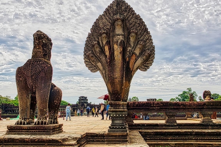 Historic stone statues with tourists exploring.