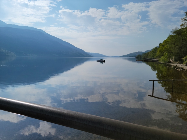 Calm lake with reflections of mountains and sky.