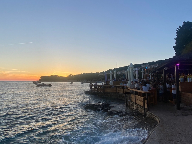       A scenic view of the sea with a setting sun in the background.
  
