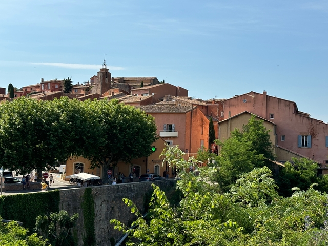 A colorful village with trees and church tower.