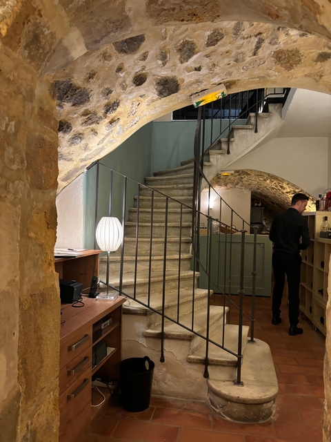 Indoor stone staircase with a person standing.