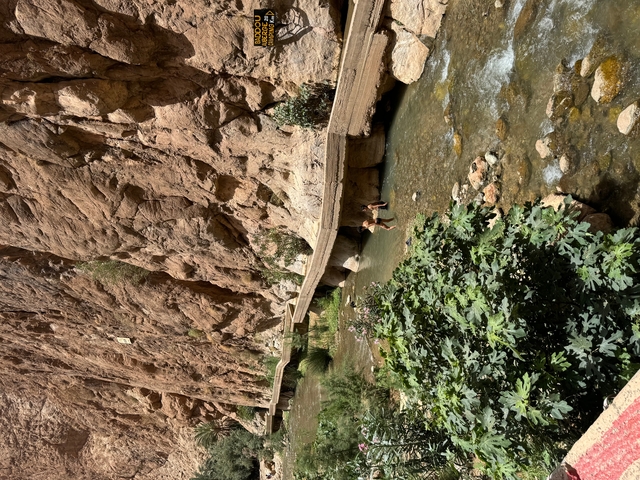       Tourists walking across a bridge over a river.
  
