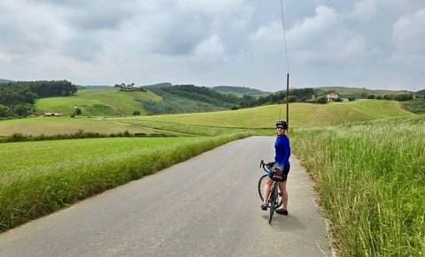 A cyclist pausing in a rural landscape.