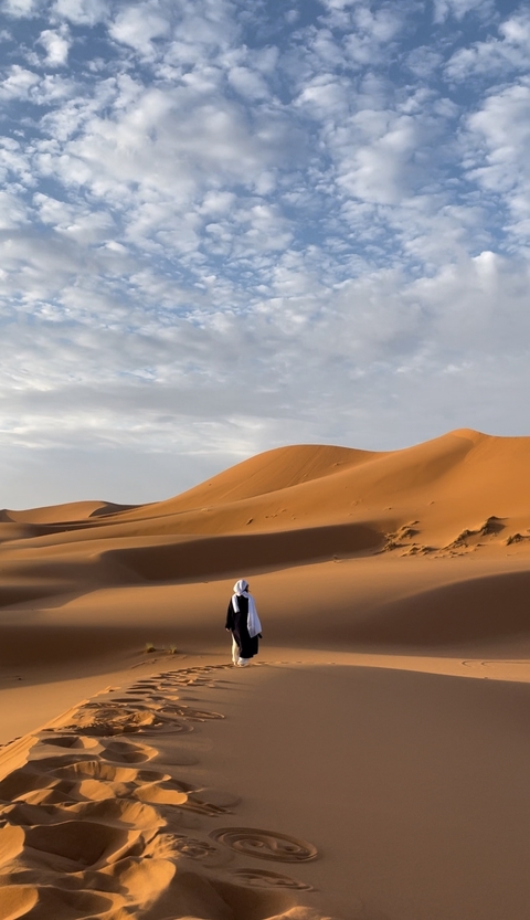 Person in the desert with sand dunes.