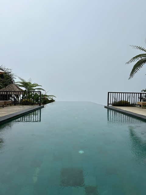       Infinity pool overlooking a foggy landscape.
  
