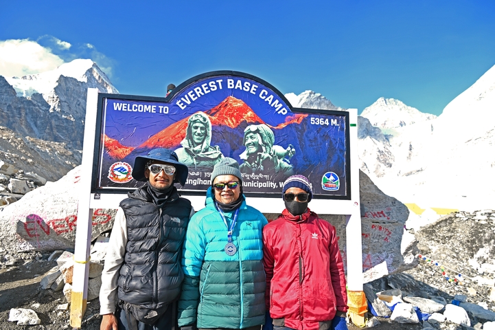       Group of people posing at Everest Base Camp with the sign in view.
  