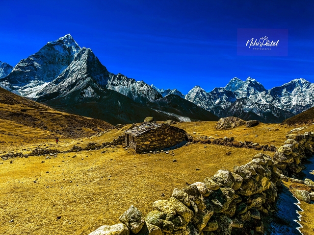 Mountain landscape with a small stone hut, featuring a watermark.