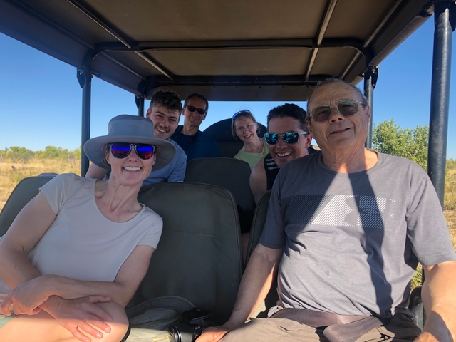 Group of people smiling inside a safari vehicle.