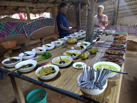 Traditional Sri Lankan meal set on a long table in a rustic setting.