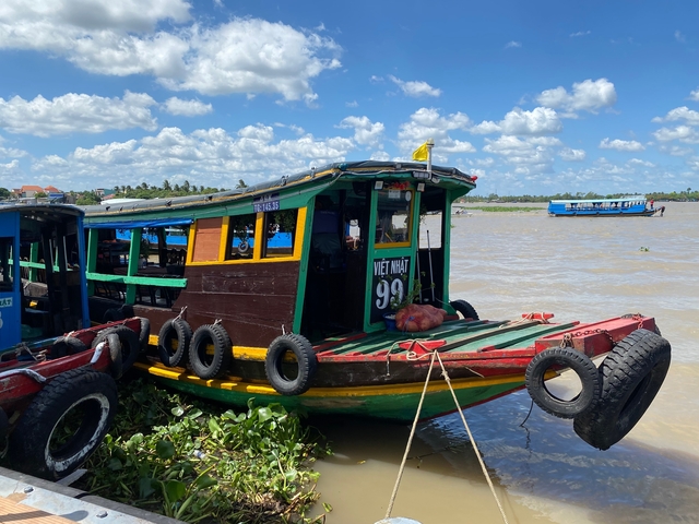       Colorful boats on a river with blue skies.
  