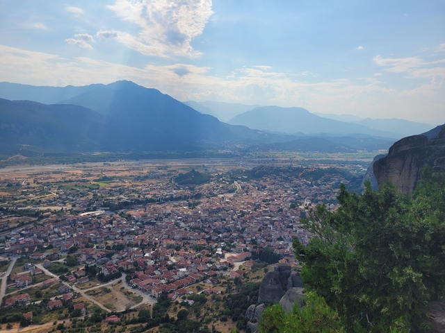 View of a valley and distant mountains from a high vantage point.