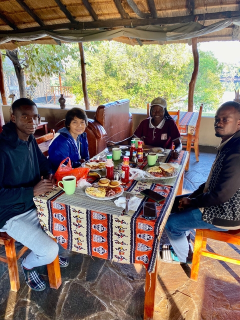 People dining at a table with assorted food items.