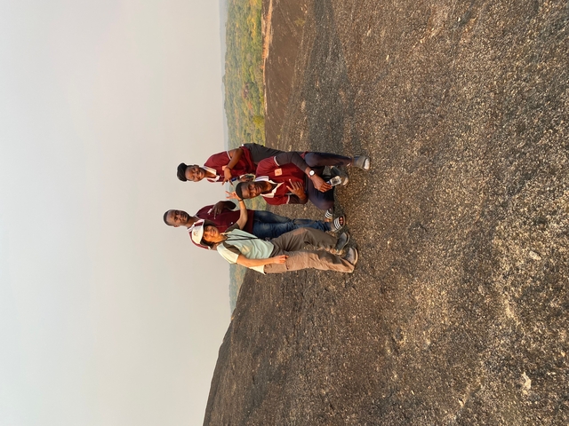 Group of people posing on a rocky landscape.