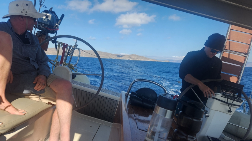       People sailing on a boat with blue seas and skies around.
  