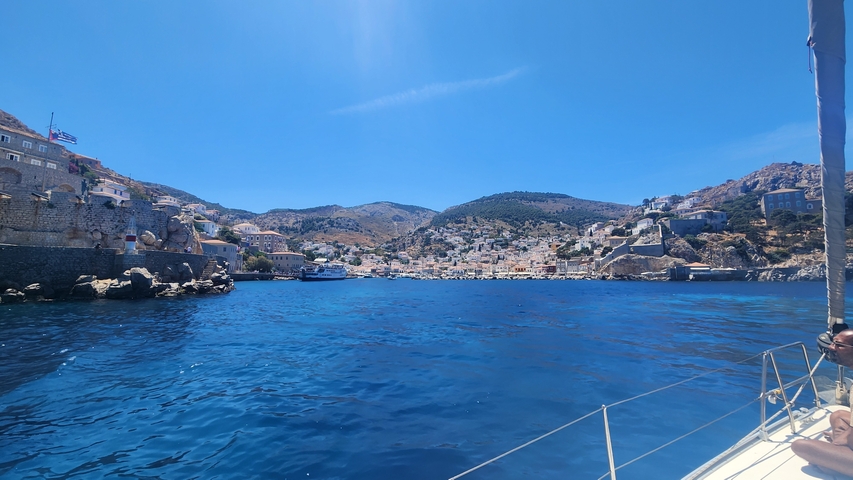       Coastal town with blue water and hills.
  