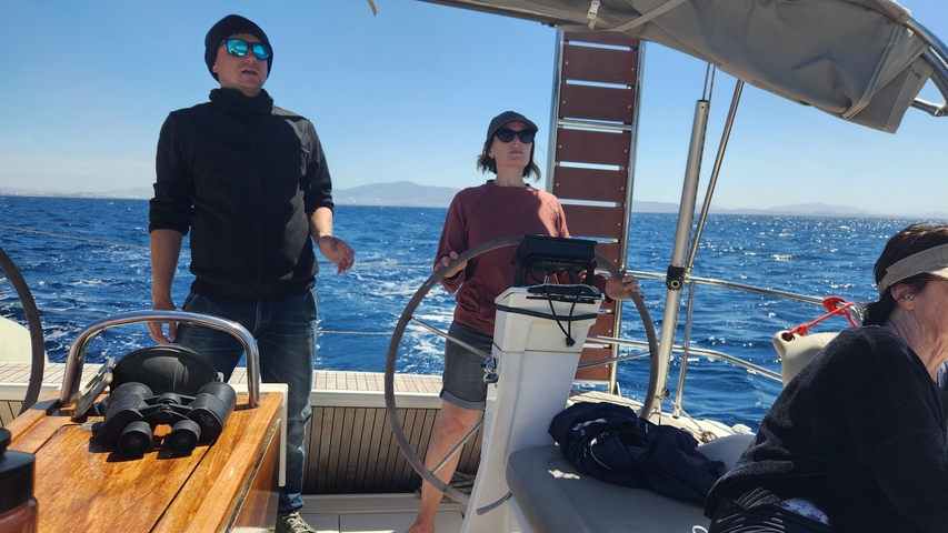       People sailing on a boat in the open sea.
  