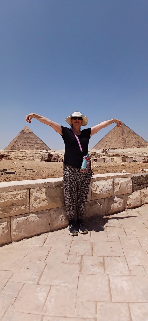 Woman posing with the Pyramids of Giza in the background.