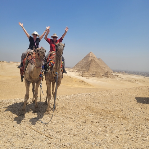 Couple on camels in front of the Pyramids of Giza.