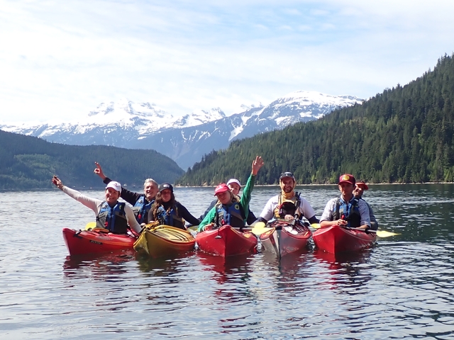Group of kayakers on a serene mountain lake.