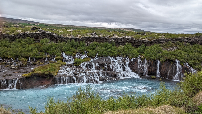 Small waterfalls flowing over a mossy rock formation.