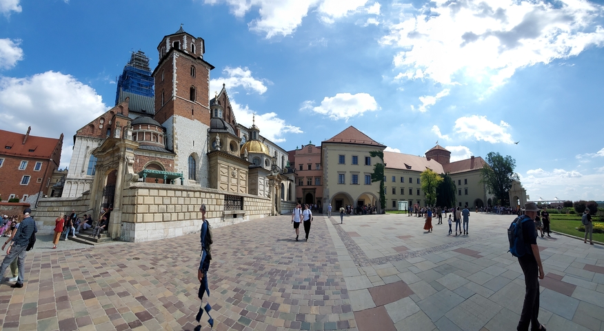       Wide view of a historical site with cathedral and tower.
  