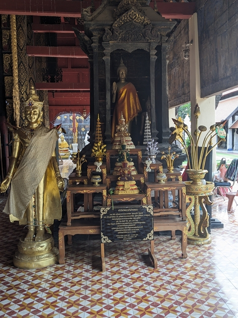       Buddhist statues and offerings in a temple courtyard.
  