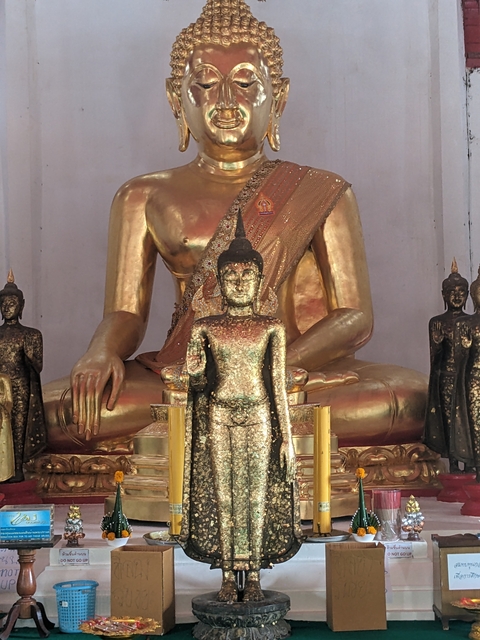       Golden Buddha and smaller statues in a temple.
  