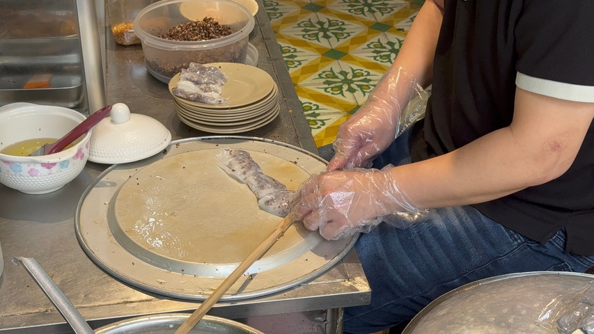 Person preparing a traditional Vietnamese dish.