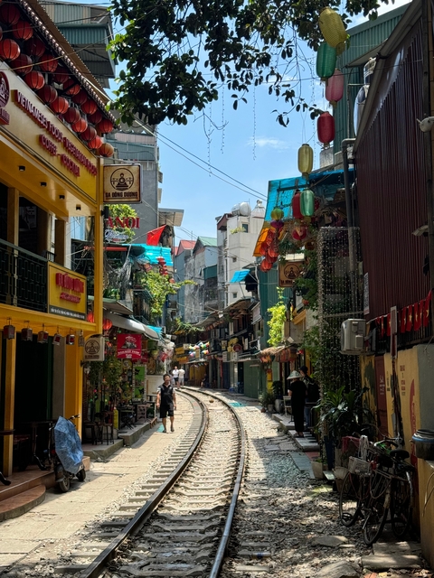 Narrow street decorated with vibrant lanterns and shops.