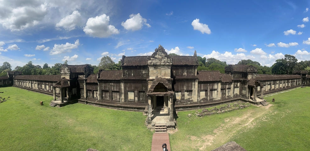 Panoramic view of an ancient structure surrounded by greenery.