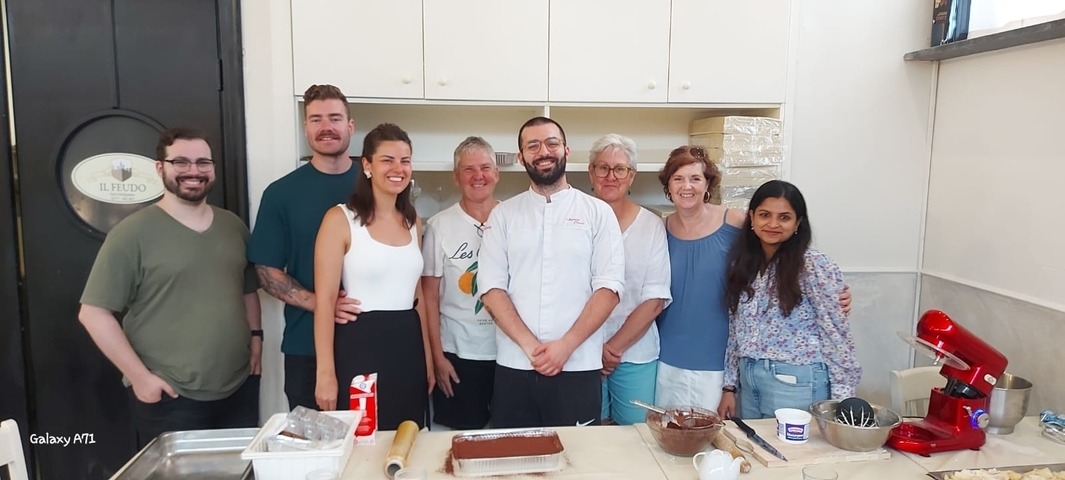 Group of people in a cooking class with a chef.
