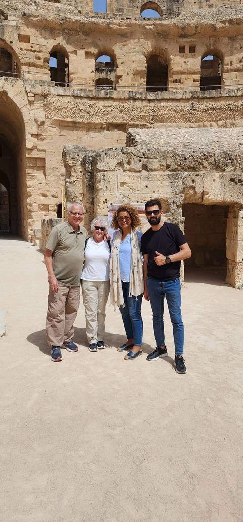 Group of people posing in front of ancient ruins.
