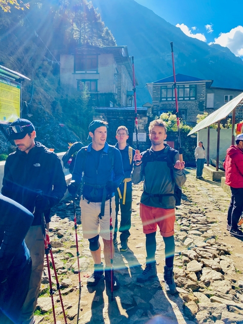       Group of hikers in a mountain village setting.
  