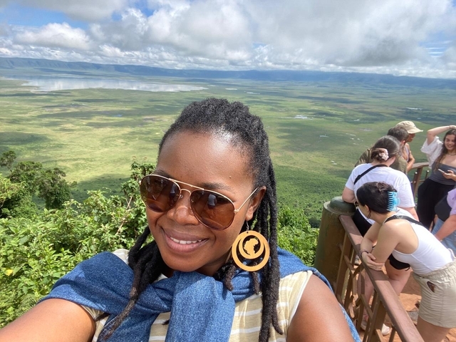       People overlooking a vast green landscape.
  