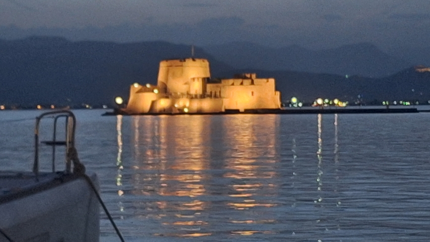      Fortress illuminated on the water at night.
  