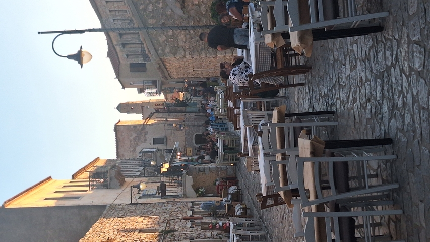       Outdoor restaurant with people dining.
  