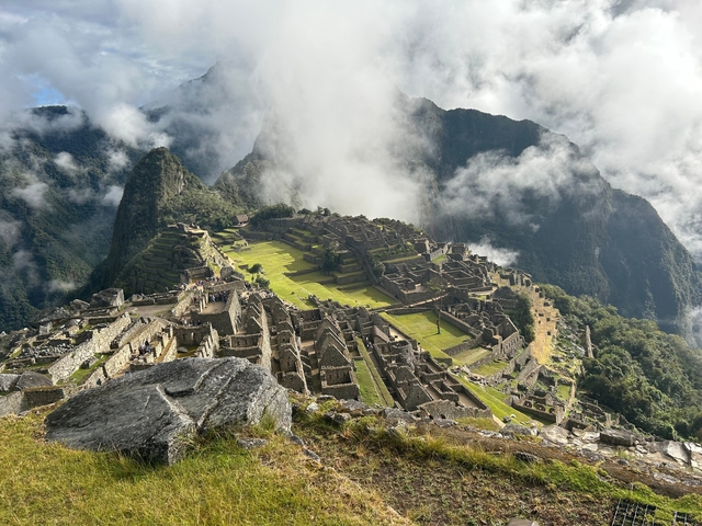       A view of Machu Picchu with fog and mountains in the background.
  