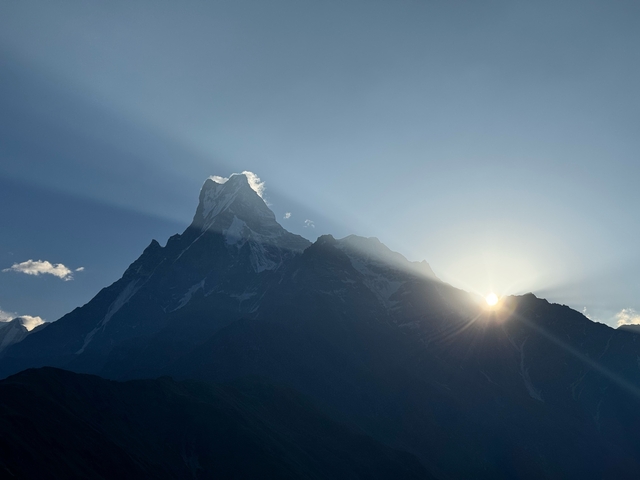 Majestic mountain peak with sun rising behind in Nepal.