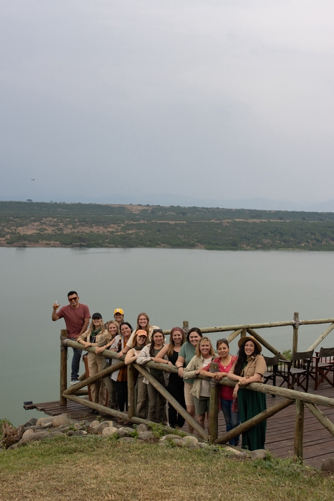       Group of people posing with a lake background.
  