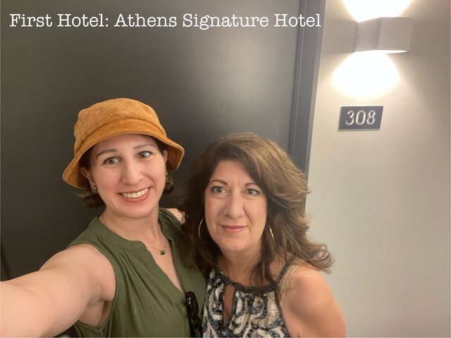       Two women posing in front of hotel room door.
  