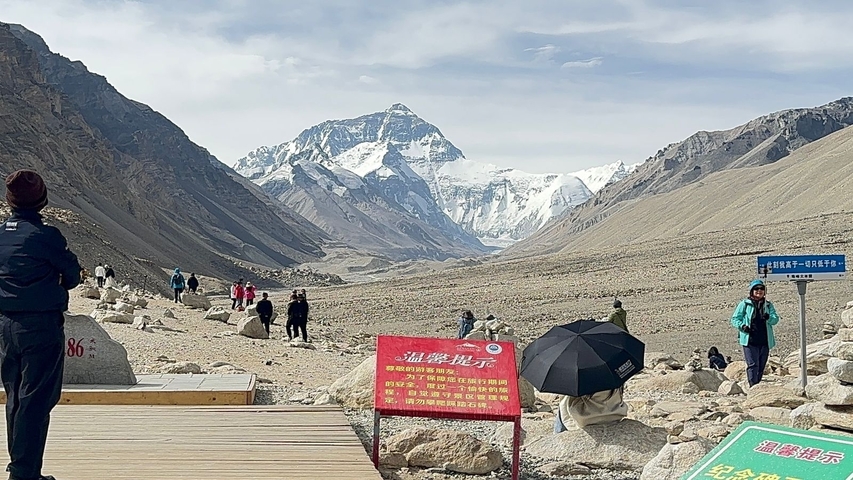 People hiking towards the base of Mount Everest with snowy scenery.