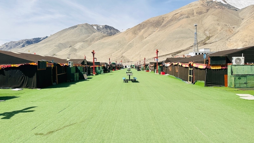 A campsite in a barren mountainous region with artificial grass.