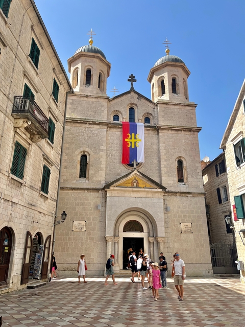       Old church with a large flag hanging on the facade.
  