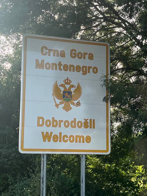       Sign with Montenegro's emblem and text welcoming visitors.
  