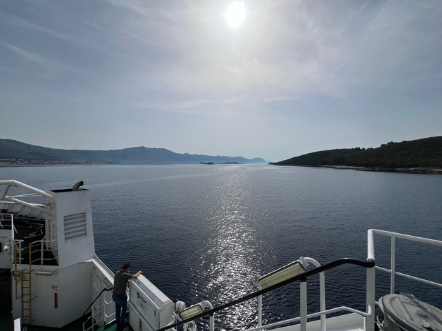       View from a boat over the sea and distant hills.
  