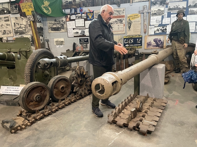       Indoors display of historical cannons with people observing.
  