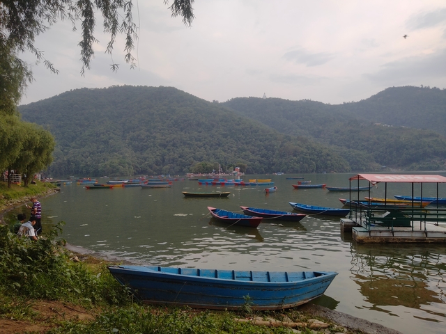      Boats floating on a lake with green hills around.
  
