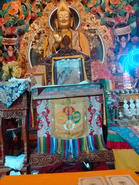 Altar with colorful traditional fabric and portraits.