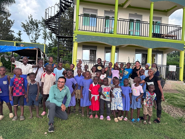 Large group of children posing in front of a residential building.
