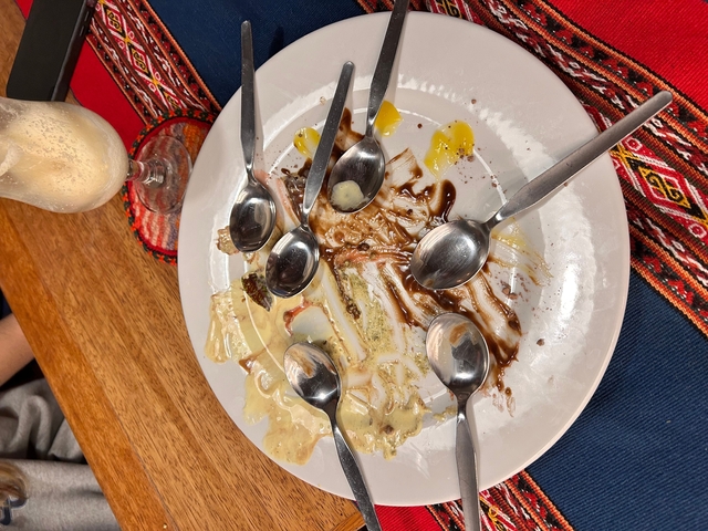 A plate with remnants of dessert and spoons around it.